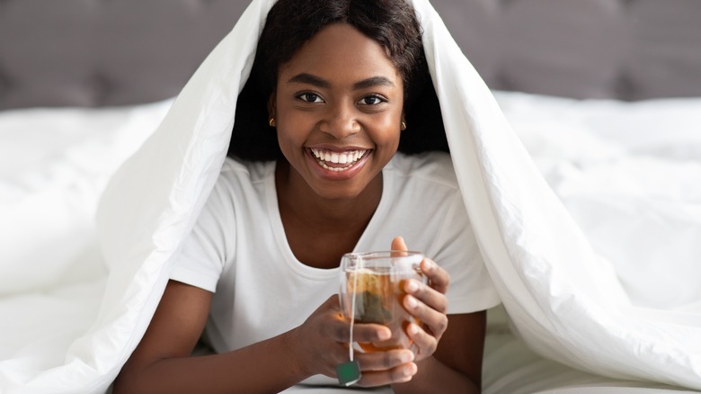 young woman smiling holding green tea