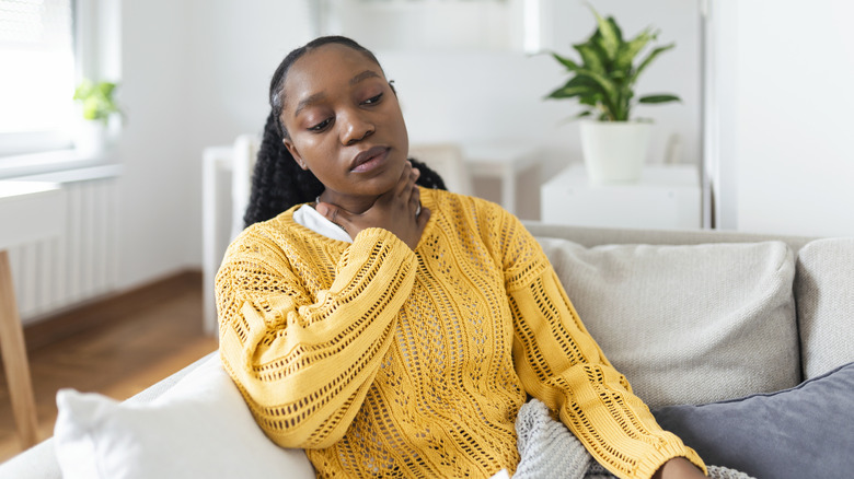 woman feeling the swelling in her neck