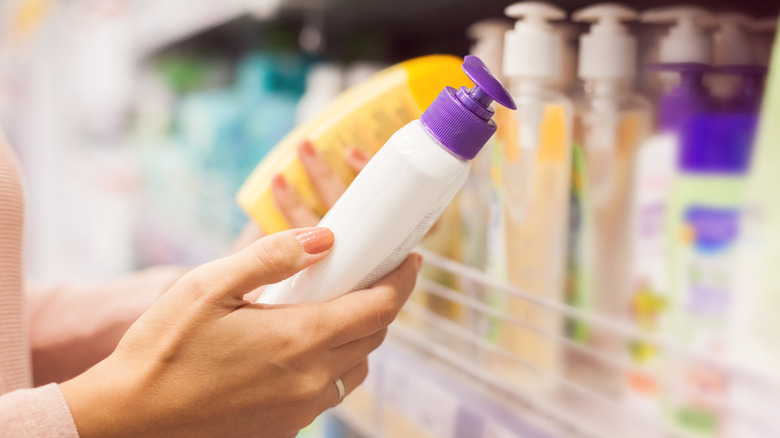 Woman choosing sunscreen at store
