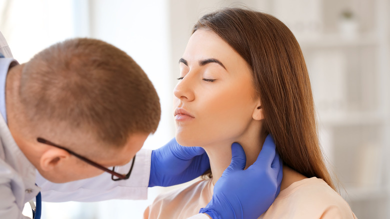 Doctor examining woman's lymph nodes
