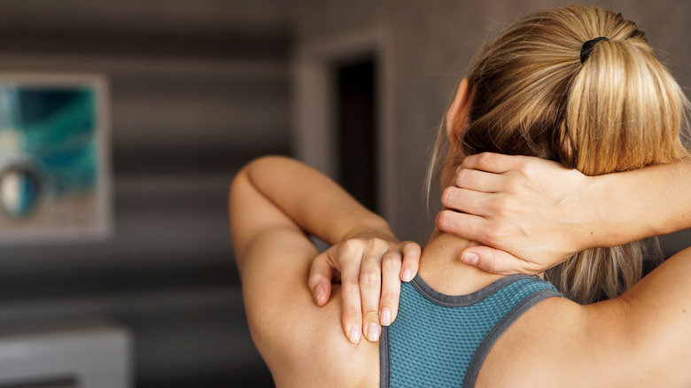 young woman feeling pain in her neck and shoulders 