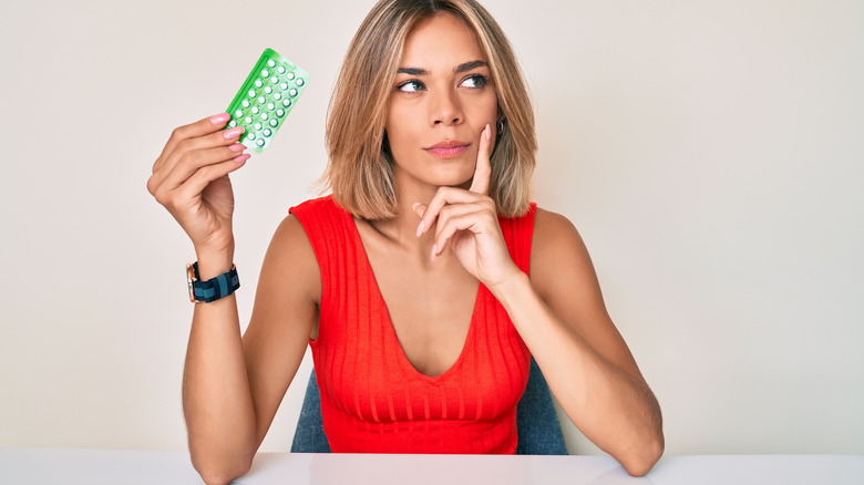 Woman holding birth control pill pack