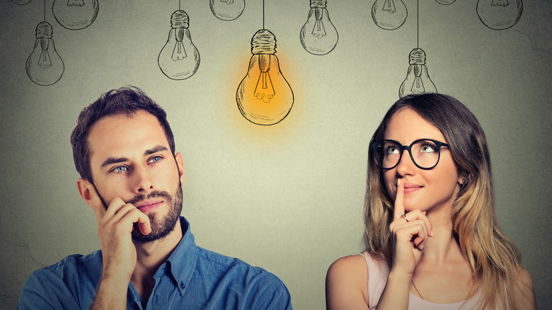 Two people thinking with lightbulbs