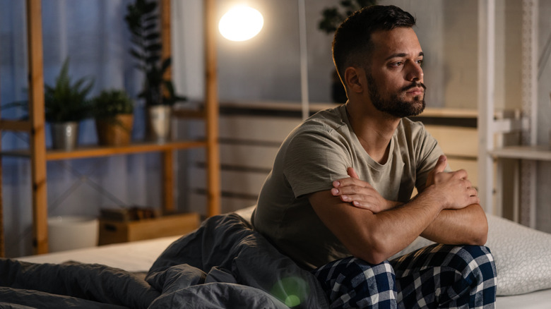 Worried man sitting on bed