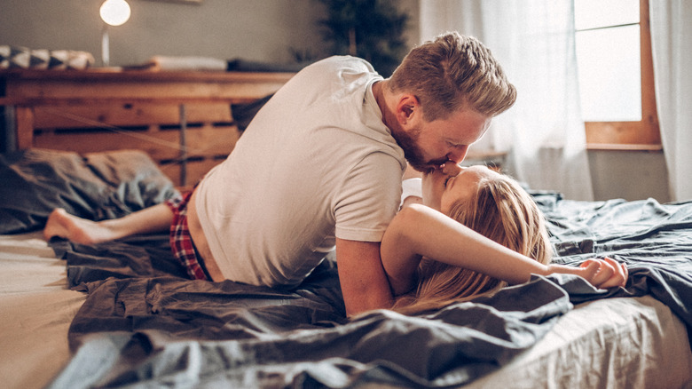 Man and woman kissing in bed