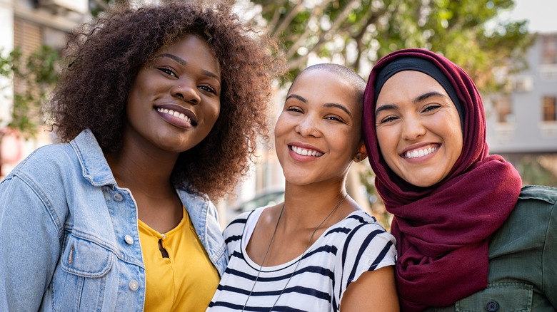 Group of three happy friends looking at camera