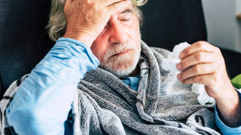 Old man holding tissues