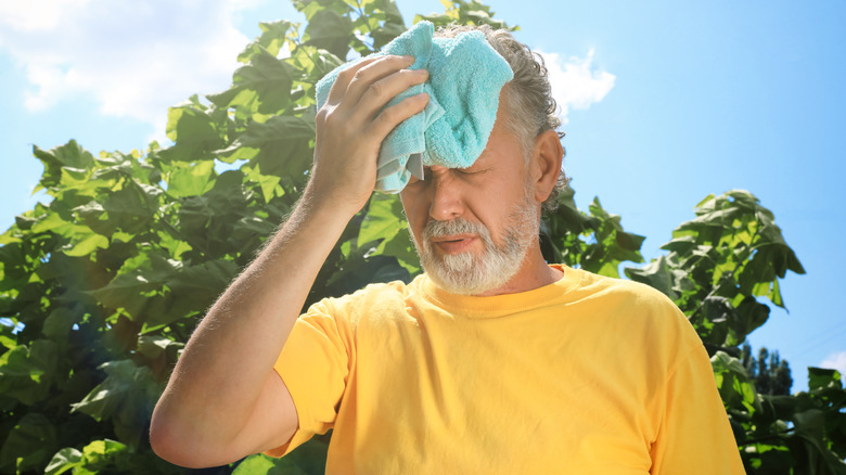 Older adult mopping forehead