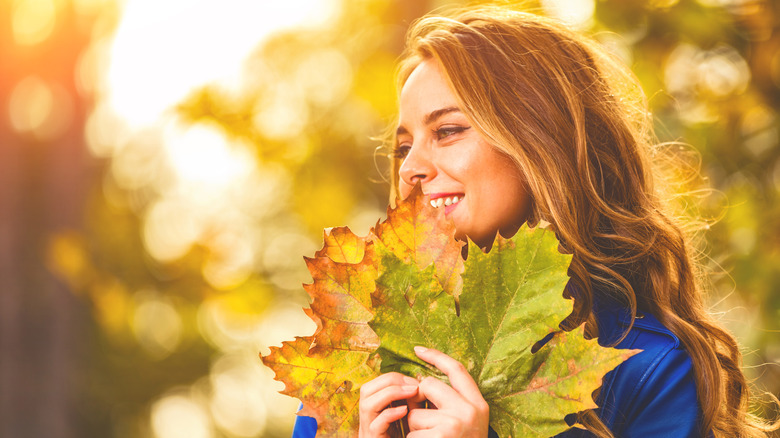 woman holding autumn leaves