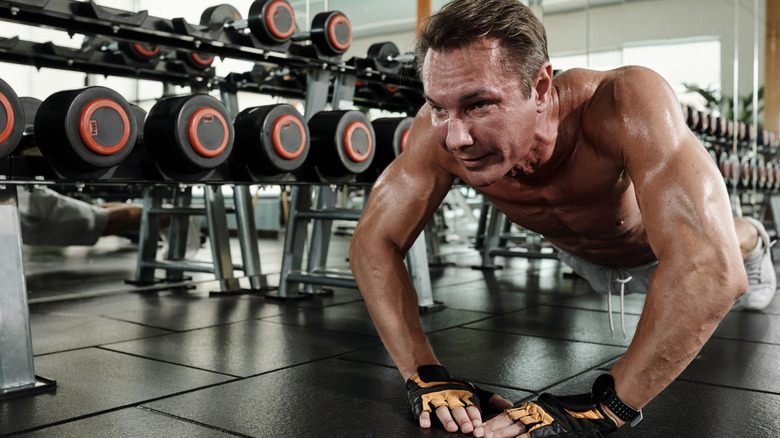 A man doing diamond push-ups at the gym