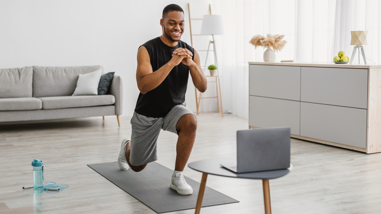 Man doing lunges on yoga mat