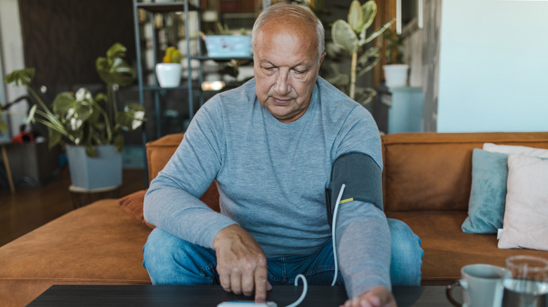 Man measuring blood pressure at home