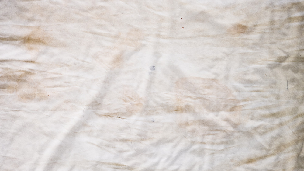 Dirty white bedding sheet, body oil stains odors stains and other dirt