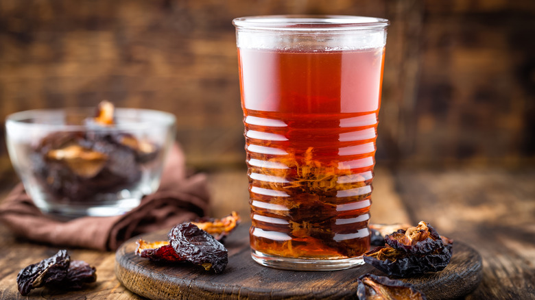 prunes on table around glass of juice