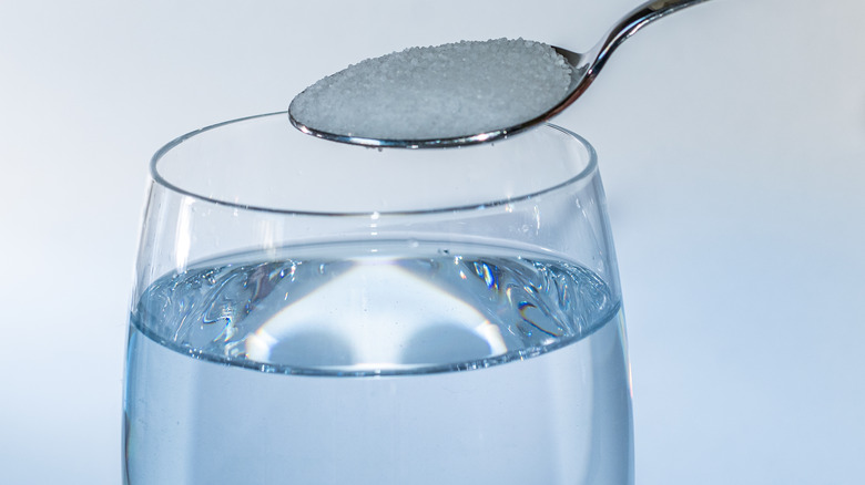 glass of water with spoon of salt 
