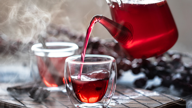 Tea pouring from a glass pot into a glass cup
