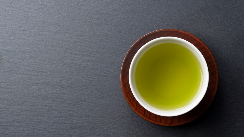 A glass cup of black tea on a white background