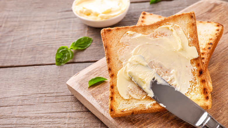 knife spreading butter on toast