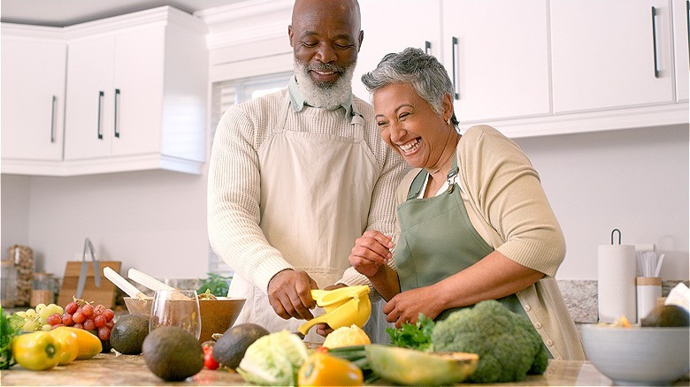 Couple preparing vegetables in kitchen