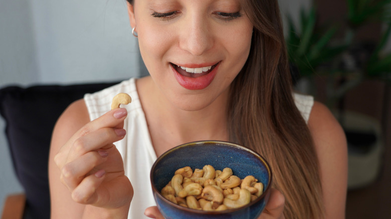 A woman holding a bowl of cashews