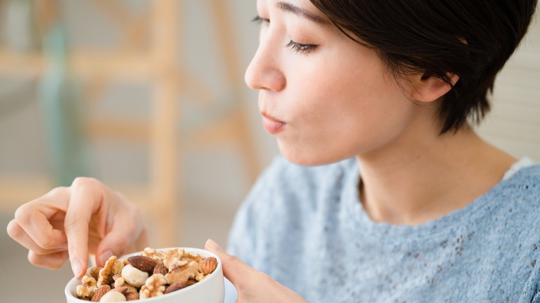 woman eating a bowl of nuts