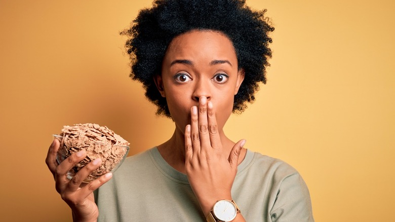 shocked woman holding cereal bowl