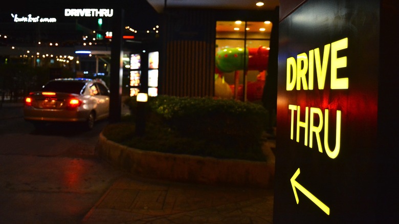 neon-lit drive thru sign at night