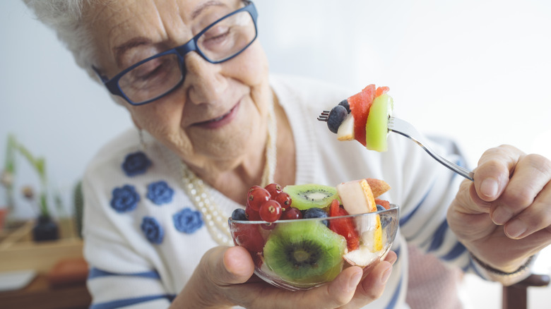 Older woman eating fruit salad