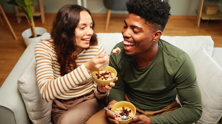 couple eating oatmeal on their couch