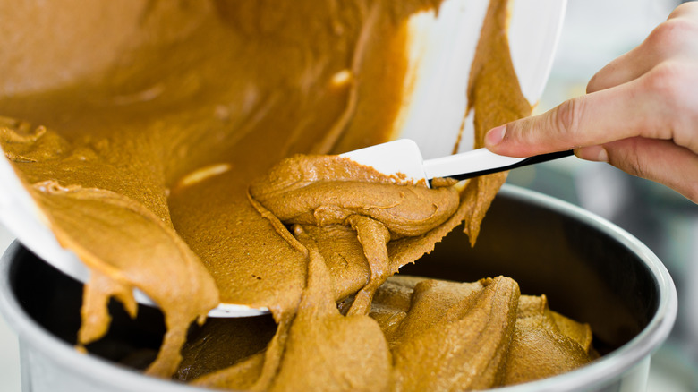 Someone putting peanut butter in bowl