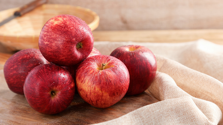 A pile of Gala apples on a cutting board