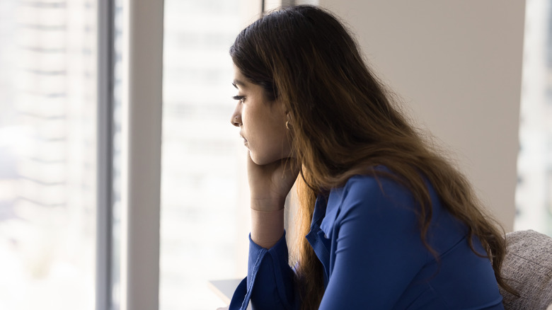Woman looking forlornly out the window