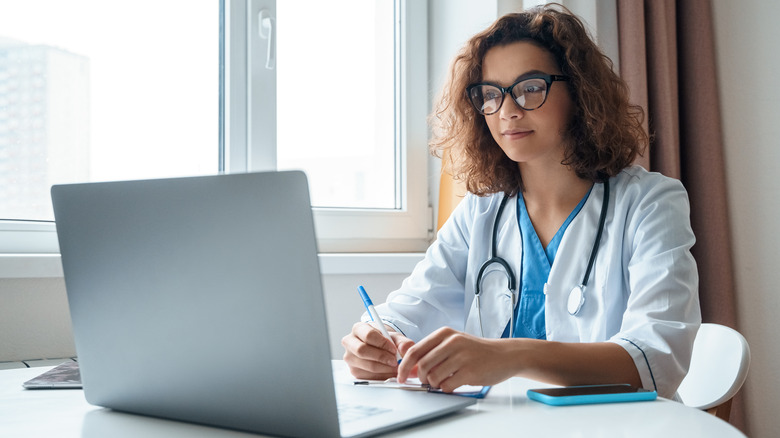 Doctor doing research on laptop