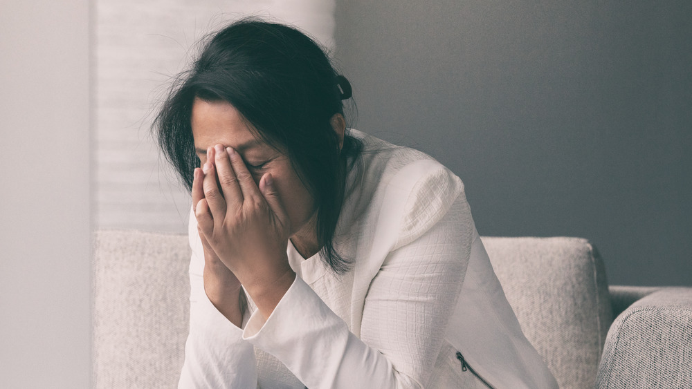 Woman crying with hands on face
