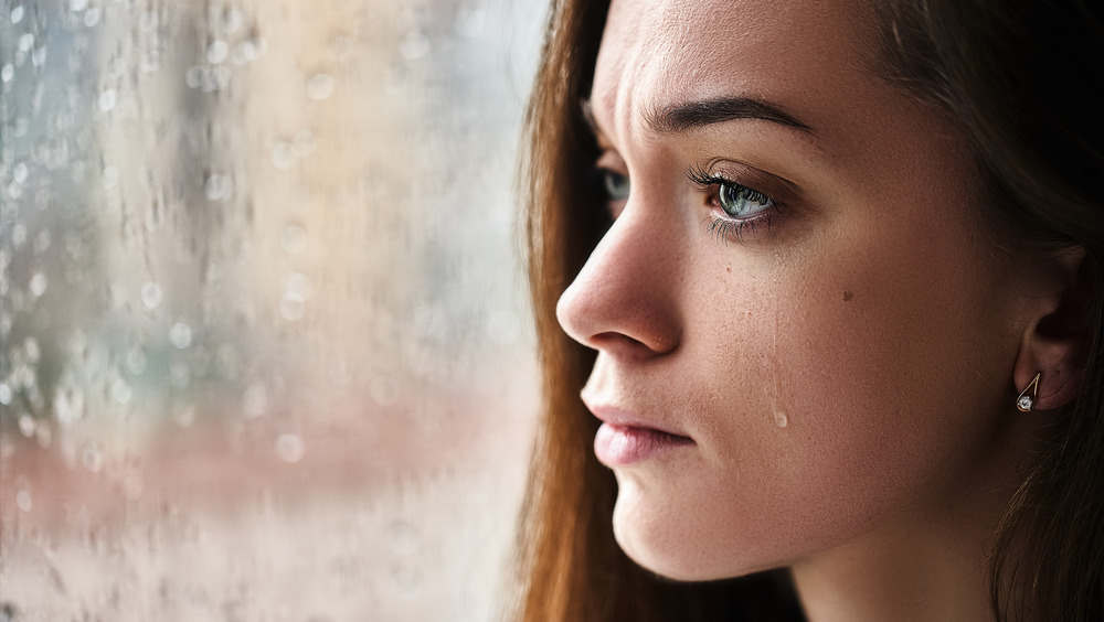 Woman crying with a tear streaming down her cheek