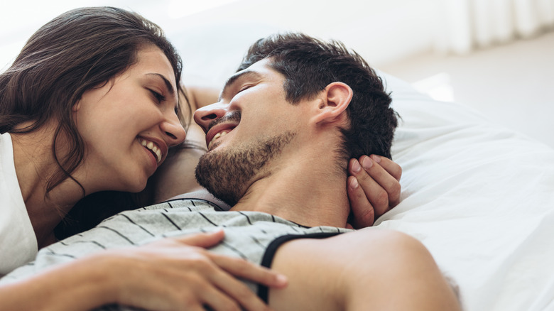happy couple cuddling in bed 
