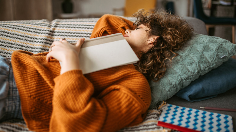 Woman napping with book on chest