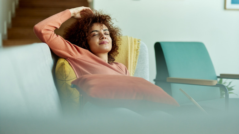 Smiling woman resting on couch