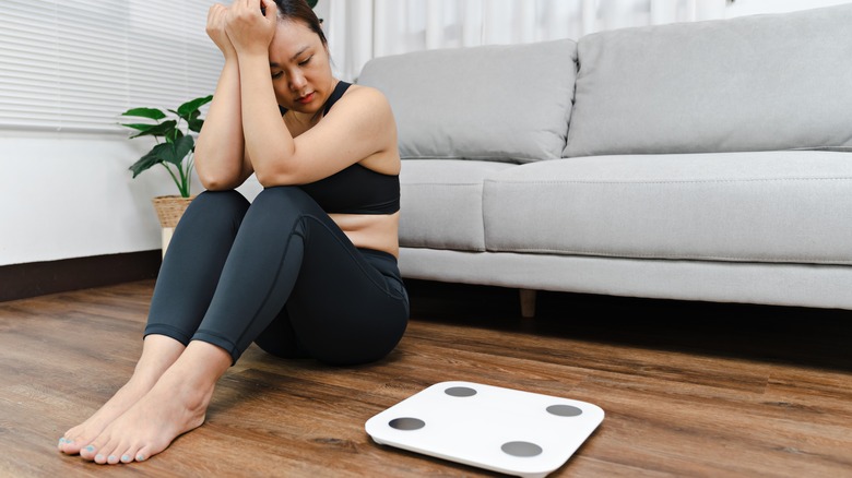 Frustrated woman sitting on floor