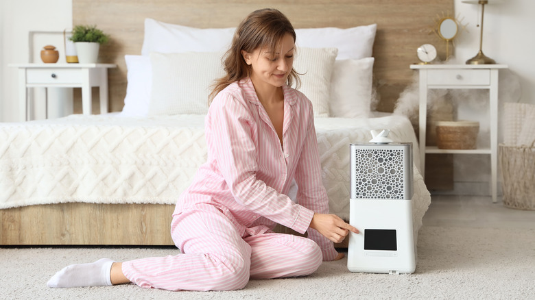 woman sitting on floor next to humidifier