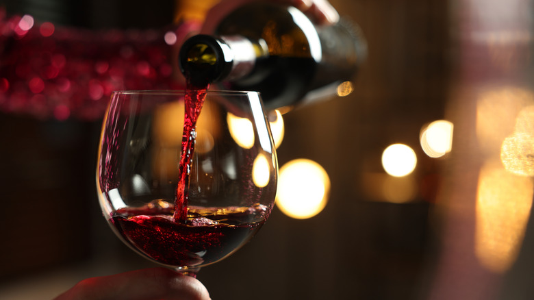 Red wine being poured from a bottle into a glass