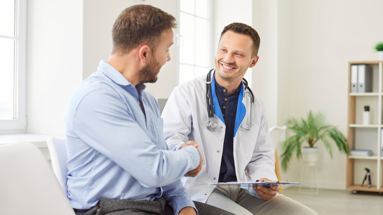 A man visiting the doctor, smiling and shaking hands