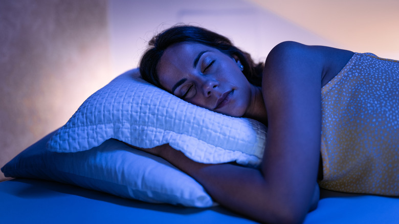 A woman sound asleep and comfortable in bed