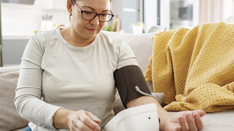 woman checking her blood pressure at home