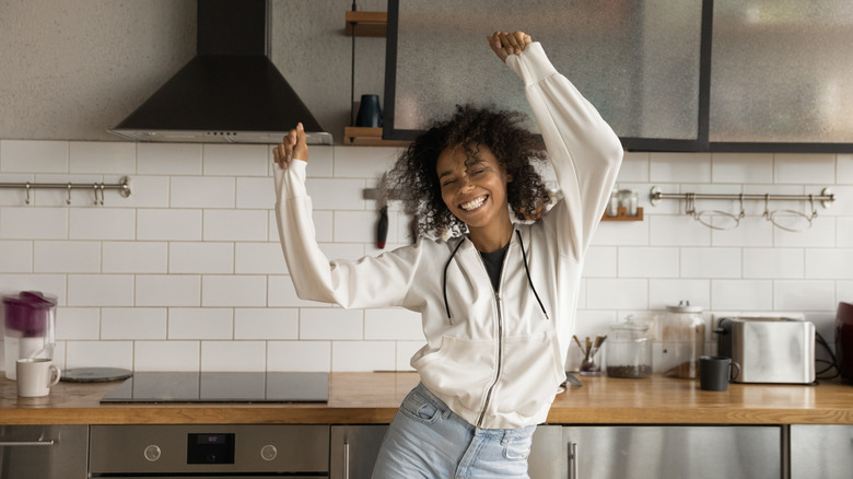energetic woman dancing in kitchen