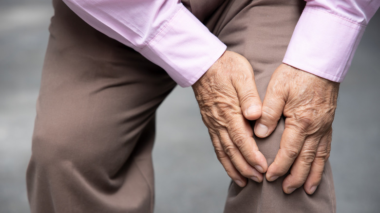 man holds painful knee