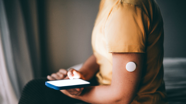 person with glucose monitor on their arm