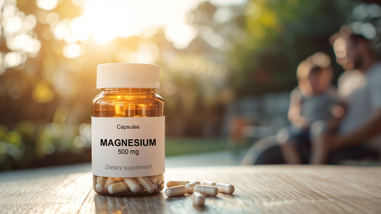 Amber bottle of magnesium supplement capsules on wooden table