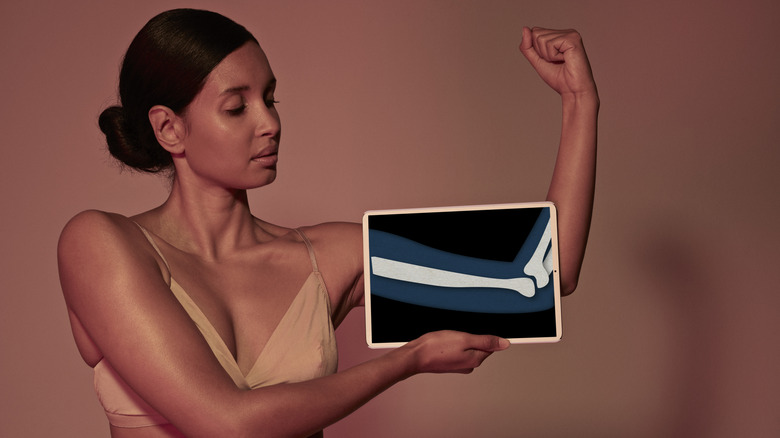 Woman holding a tablet in front of her arm with an x-ray drawing referencing strong bones