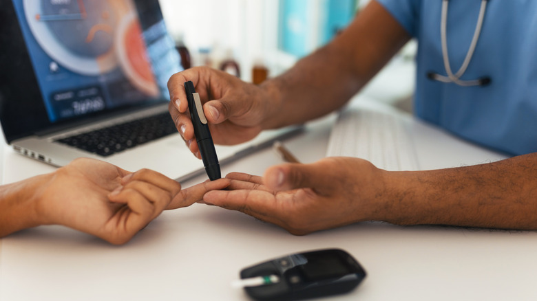 Doctor testing blood sugar levels from a patient's finger